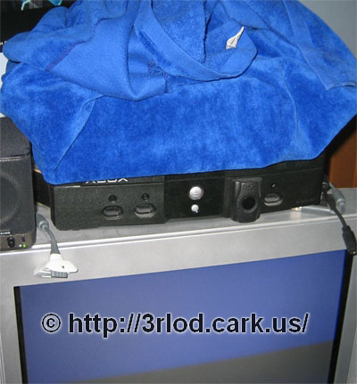 Xbox 360 wrapped in a towel. Xbox 360 is sitting above the original Xbox.