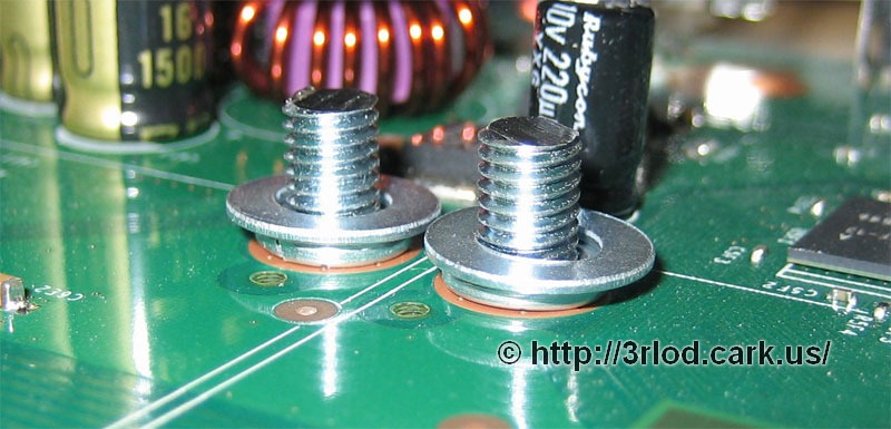Close up of flattend spring washer, and flat metal washer on top.